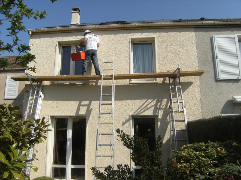 Ravalement de façade en cours sur une maison avec échafaudage