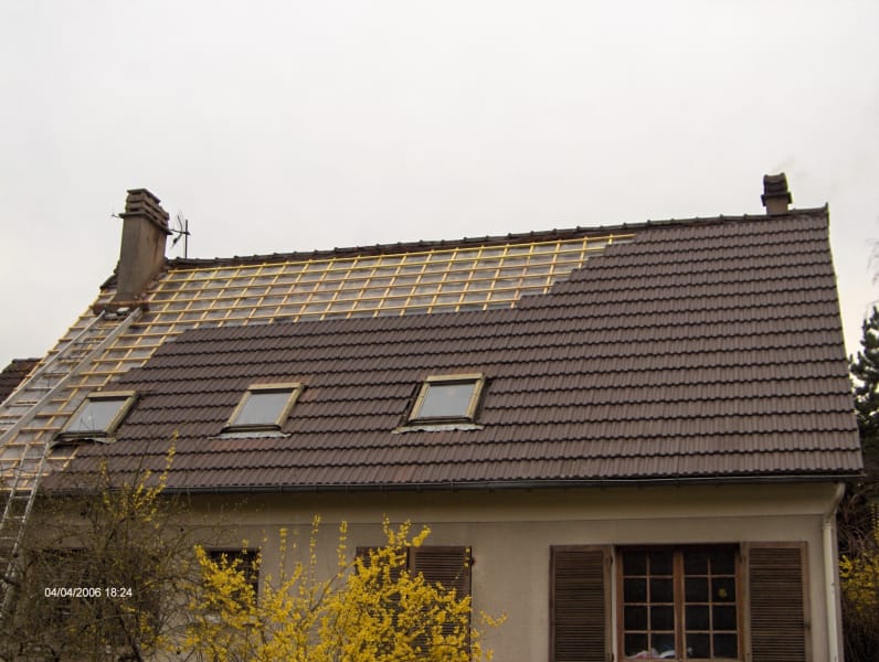 Réfection de toiture en cours : liteaunage neuf et tuiles brunes